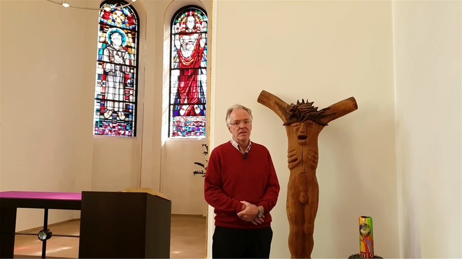 Diakon Manfred Liesbrock geht auf einen Rundgang durch die Kapelle des Elisabeth-Krankenhauses. Besonders geht er auf die Christus-Darstellung (rechts im Bild) ein.